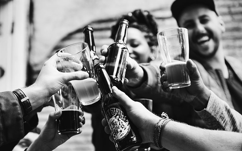 Jóvenes de fiesta brindando con alcohol